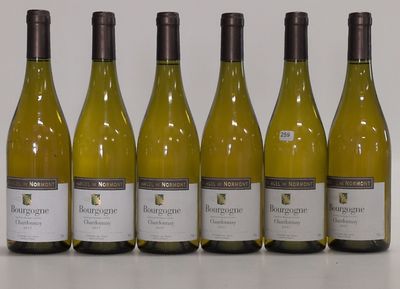 six bottles of white wine are lined up on a table