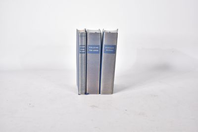 deux livres sont empilés l'un sur l'autre sur une surface blanche