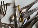 a lot of silver spoons and forks on the table