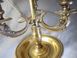 a brass candelier with three candles on it