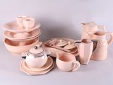 beaucoup d'assiettes et de tasses roses et blanches sur la table