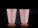 une paire de vases en verre rose sur fond noir
