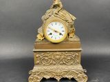 une horloge en or surmontée d'une statue