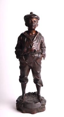 bronze statue of a boy with a hat and a baseball cap