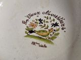 a plate with a bird and flowers on it