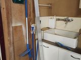 une photo d'une salle de bains avec un lavabo et un balai