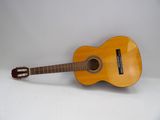 une image représentant une guitare posée sur une surface blanche