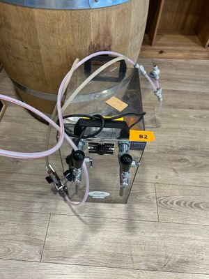 une photo d'un distributeur de vin posé sur un parquet