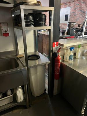 a kitchen with a sink, stove, and shelves in it