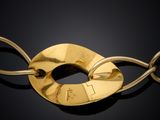 a close up of a gold plated necklace on a black surface