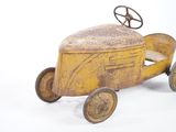 a yellow toy car with a steering on a white background