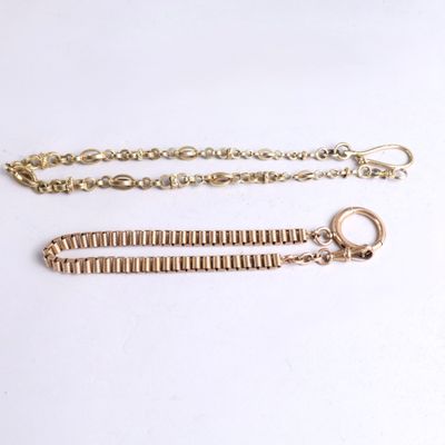 a close up of two gold chains on a white surface