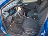 the interior of a blue car with a steering wheel and dashboard