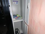 a bathroom with a toilet and a cabinet in it