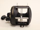 a close up of a fishing reel on a white surface