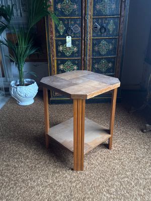 a small wooden table with a shelf in the middle of the room