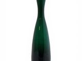 a green vase that is sitting on a white surface