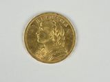 l'image d'une pièce d'or posée sur une surface blanche
