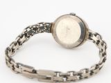 a close up of a wrist watch with a chain around it