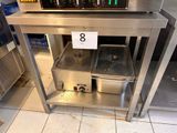 une table sur laquelle sont posées deux casseroles, avec une étiquette de prix dessus