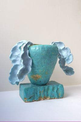 un vase bleu contenant une fleur, posé sur une table