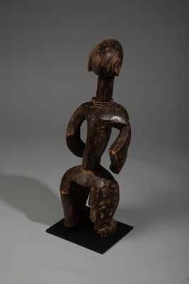 une statue en bois d'un homme avec un chapeau sur la tête