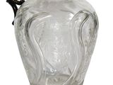 a clear glass pitcher with a black handle on a white background