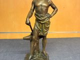 statue en bronze représentant un garçon tenant un parapluie et debout sur un rocher