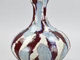 a blue and red vase sitting on a white surface