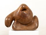 wooden sculpture of a dog sitting on top of a white pedestal