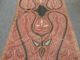 an old carpet with a design on it in a room