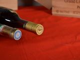 two bottles of wine sitting on a red cloth