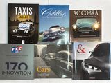 plusieurs livres posés sur une table blanche, avec une voiture en arrière-plan