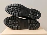 the soles of a pair of black boots on top of a white box