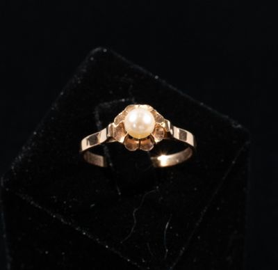 a close up of a gold ring with a pearl in it