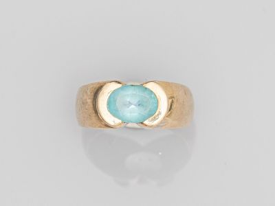 une bague en or avec une pierre bleue au centre