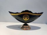 a black and gold bowl with a gold decoration on it