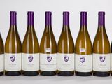 six bouteilles de vin sont alignées sur une surface blanche
