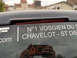 une personne en train de prendre une photo d'une voiture avec son téléphone portable
