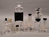 several bottles of perfume sitting next to each other on a white surface