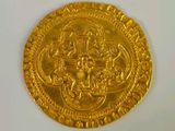 an image of a gold coin sitting on top of a white surface