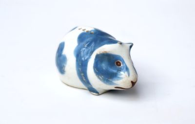 a small blue and white animal figurine on a white surface
