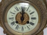 a gold clock with roman numerals on the face of it