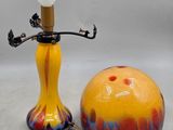brightly colored lamp with a stick and a ball on a white surface