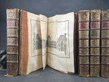 trois vieux livres ouverts sur une table