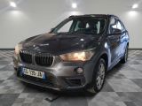 la bmw x1 est garée dans une grande pièce au sol en damier