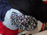 a pile of clothes that is laying on a bed
