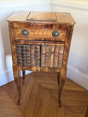 a small wooden table with books on top of it