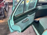 a green car with a door open in a parking lot