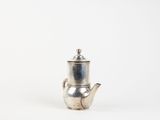 an old silver teapot with a handle on a white background